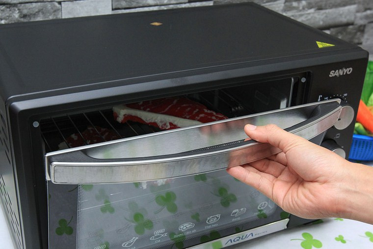 Alt: Lò nướng đang hoạt động, bên trong có thức ăn đang được nướng chín vàng, thể hiện sự tiện lợi và tiết kiệm năng lượng khi sử dụng đúng cách