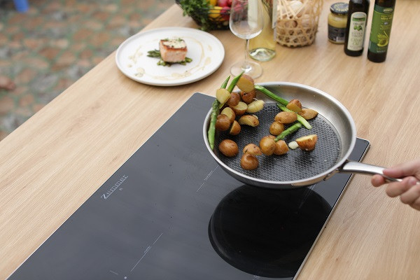 alt=Hình ảnh mặt bếp từ Satochi không nóng khi đang nấu, an toàn cho trẻ nhỏ.